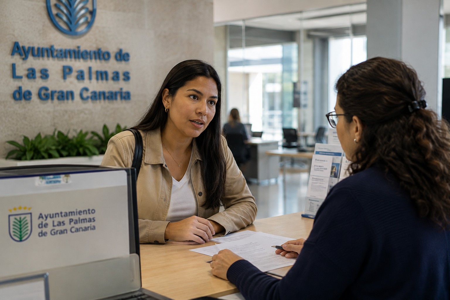 Mulher a conversar com uma funcionária ao balcão da Câmara Municipal de Las Palmas de Gran Canaria, a tratar de um trâmite administrativo