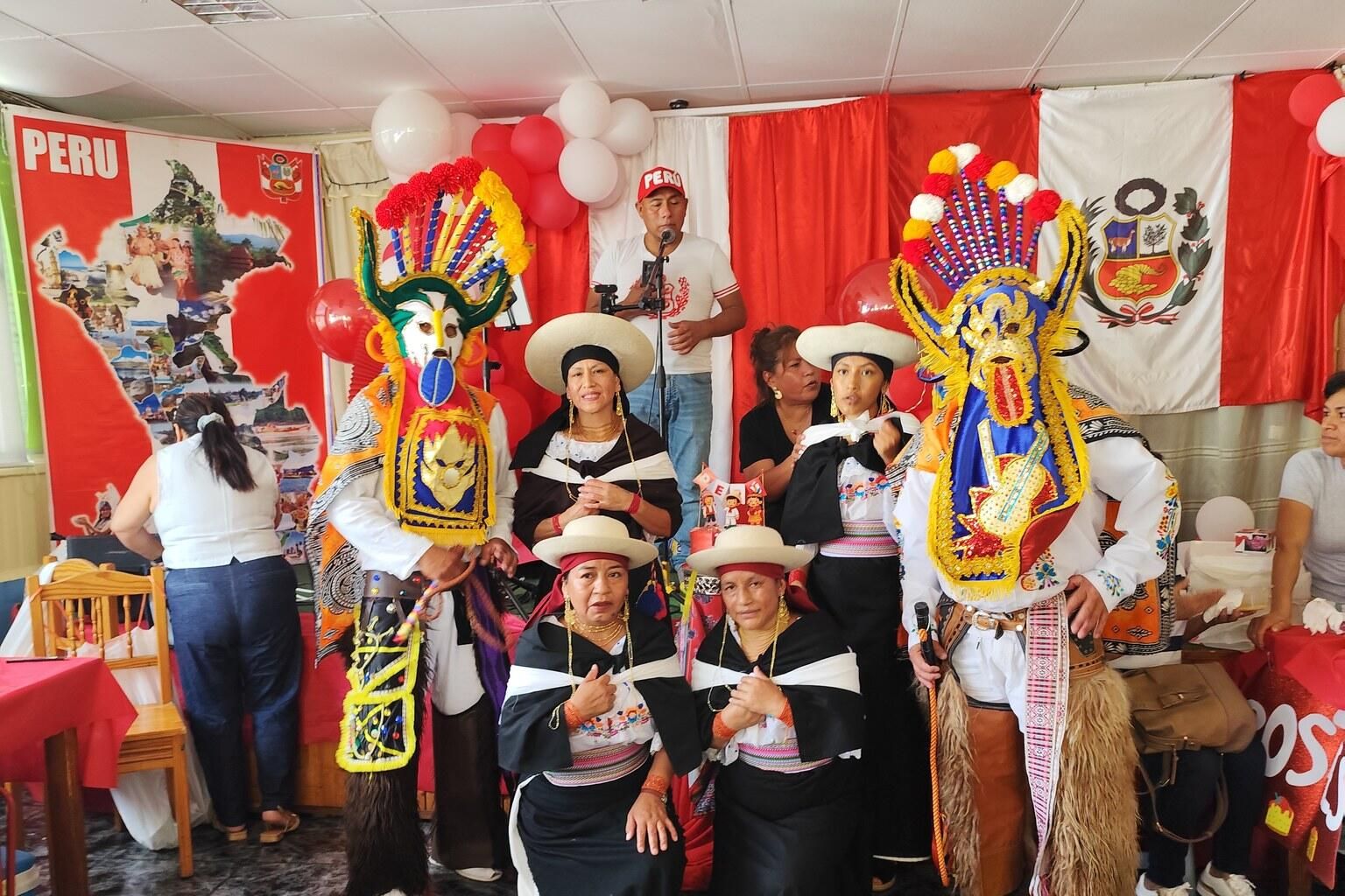 Ubuntu Canarias junto a dançarinos com trajes e máscaras tradicionais nas Fiestas Patrias da comunidade peruana em Las Palmas de Gran Canaria